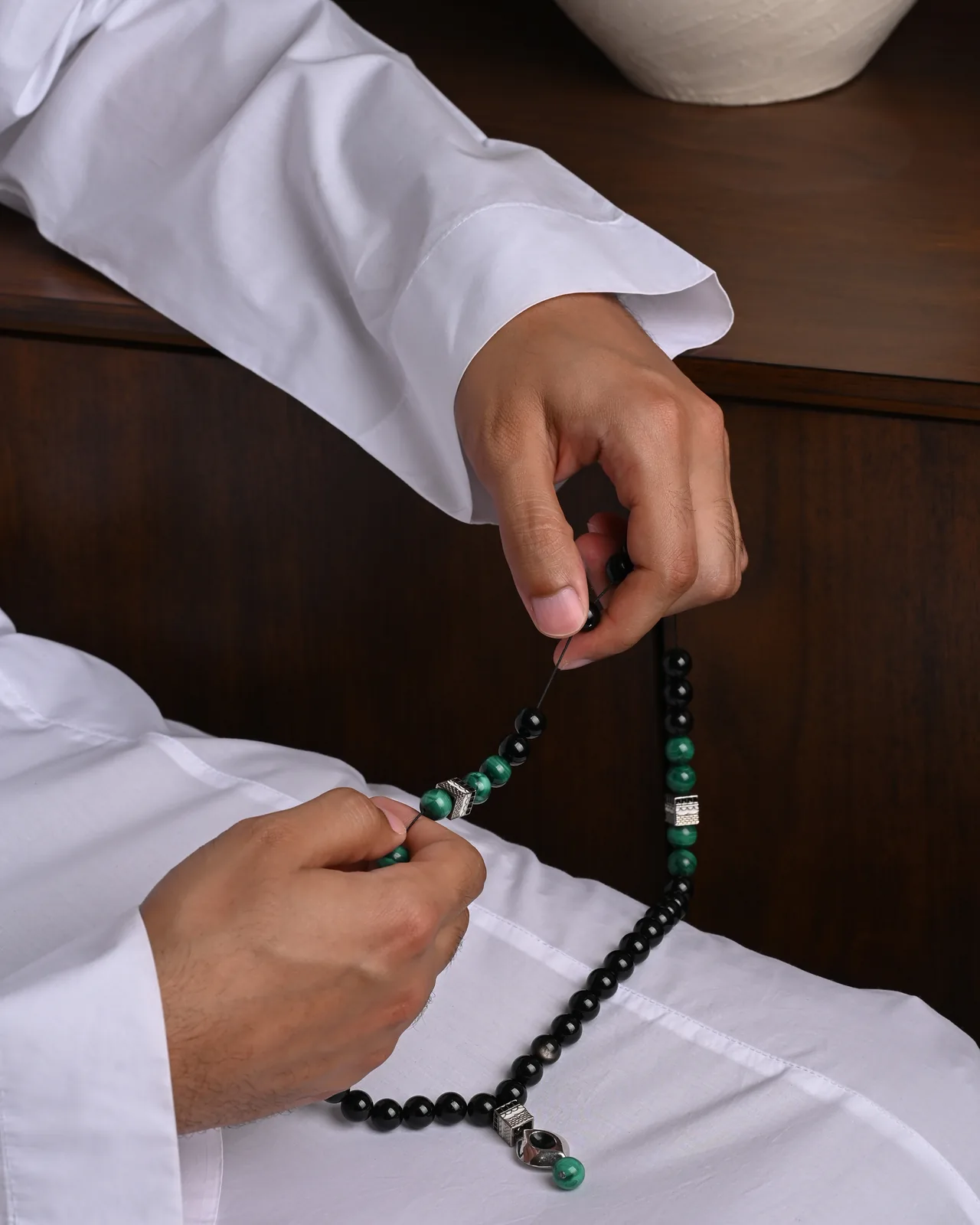 سبحة مكة المكرمة من التورمالين الأسود والمالاكايت في اليد